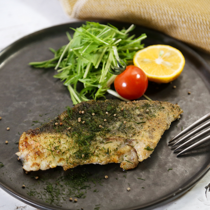 A plate of grilled fish topped with dried aonori