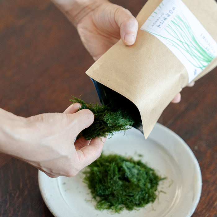 Hands taking out dried aonori from package