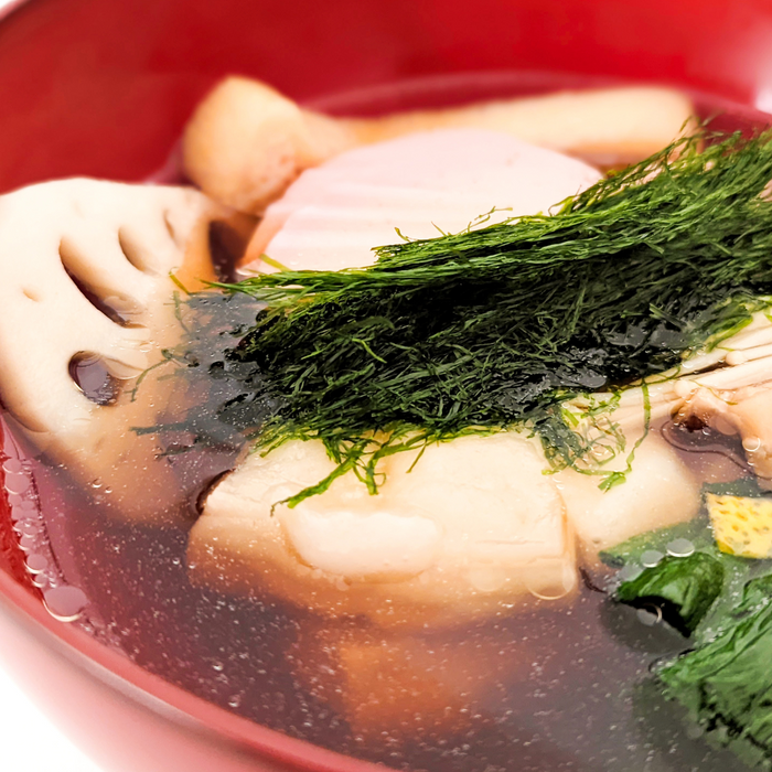 A bowl of clear soup topped with aonori