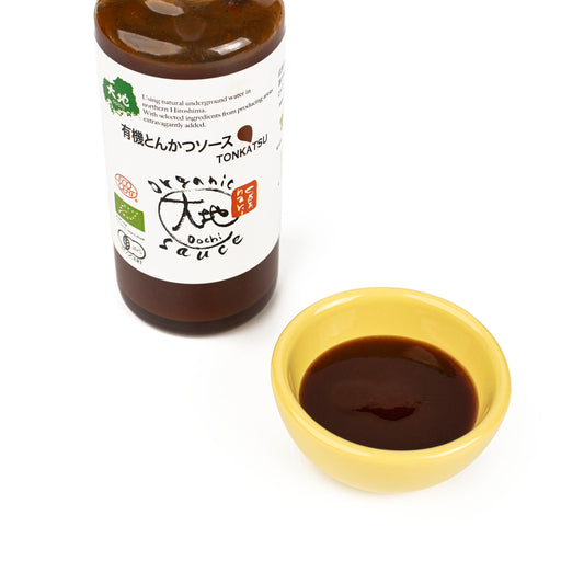 A bowl of tonkatsu sauce next to a package bottle of the product