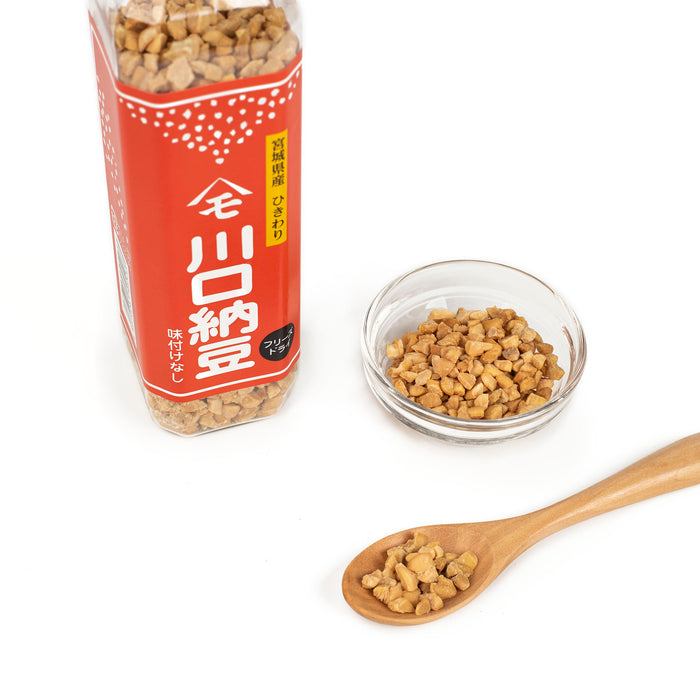 A spoon and a bowl of dried natto next to a package bottle of the product