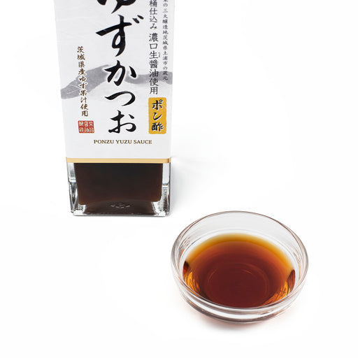 A bowl of ponzu yuzu sauce next to package bottle of the product