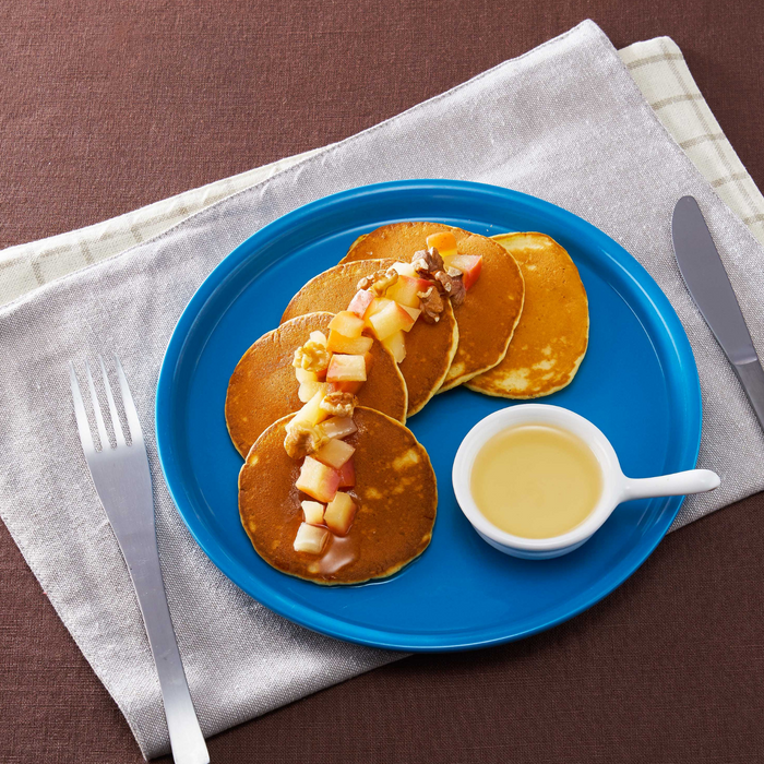 A plate of pancakes topped with diced apples