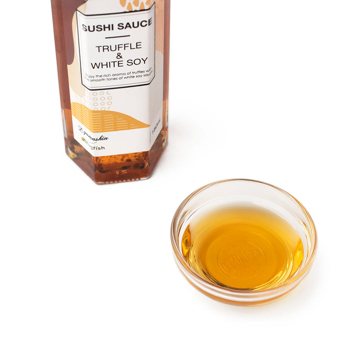 A bowl of truffle infused white soy sauce next to a bottle of the package