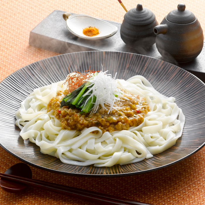 A bowl of kishimen noodles topped with minced pork