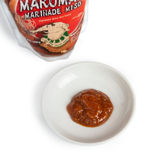 A small bowl of the miso marinade next to package