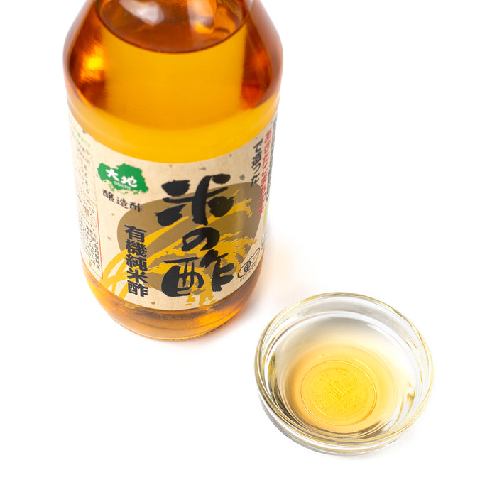 A small bowl of organic rice vinegar with bottle of the product