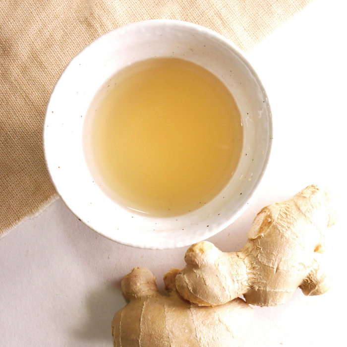 A cup of ginger tea and ginger roots