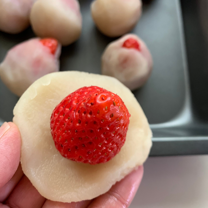 Man holding a strawberry daifuku