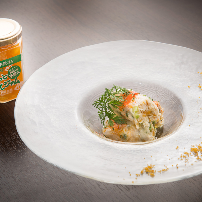 A plate of chicken dish next to a jar of the product