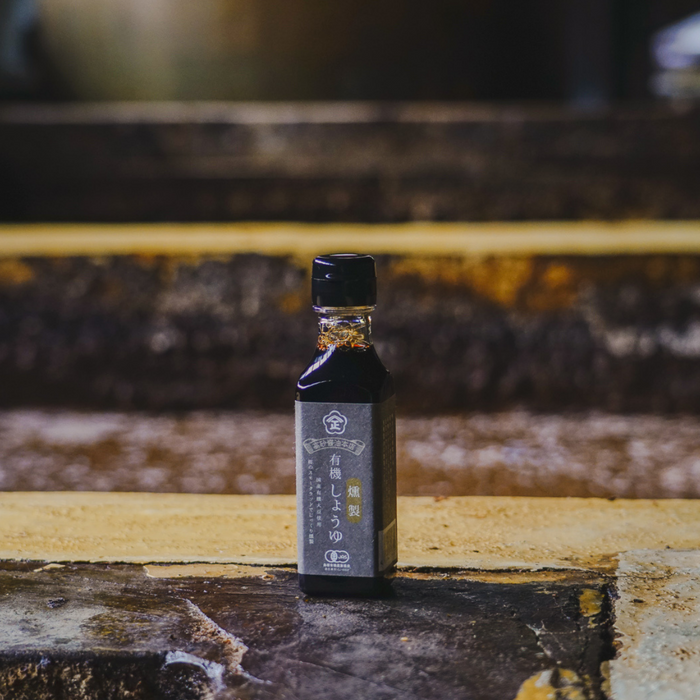 A package bottle of the product standing on wooden barrel