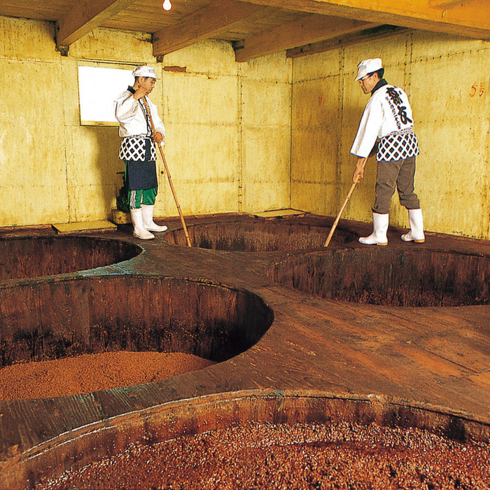 Two craftsmen stirring soy sauce