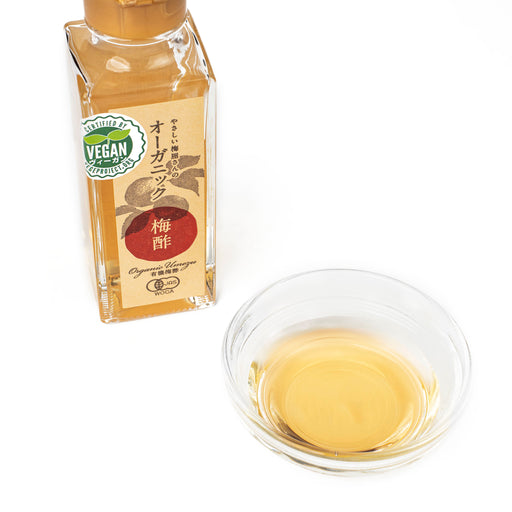 A small bowl of the organic ume vinegar next to bottle of the product