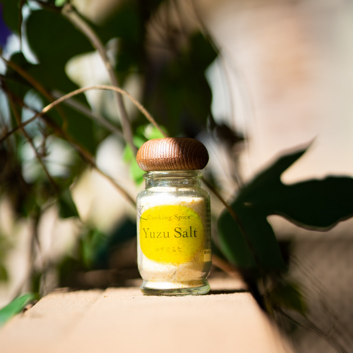 A bottle of the product in front of plants