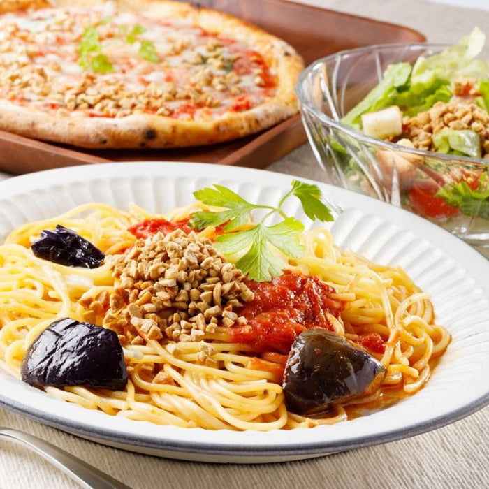 A bowl of spaghetti topped with dried natto