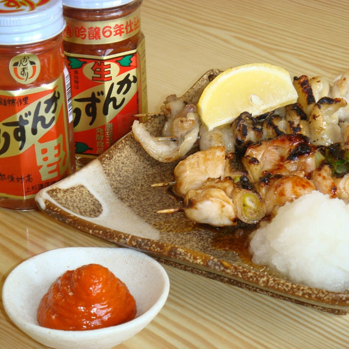 Three yakitori skewers next to two jars of the product