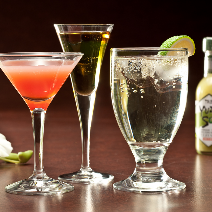 Three glasses filled with different types of cocktail standing side by side in front of a package bottle of the product