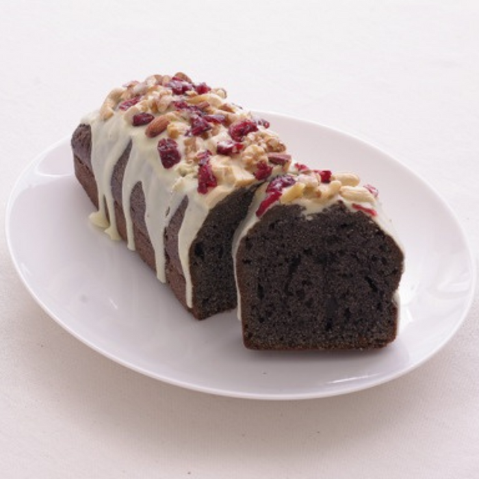 Black sesame pond cake topped with cream cheese frost and dried berries on a plate