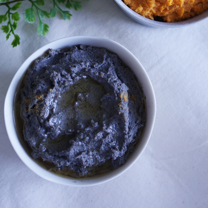 A bowl of black sesame blended hummus