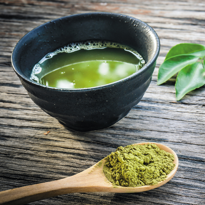 A bowl of mulberry matcha green tea with a spoon of organic mulberry matcha powder