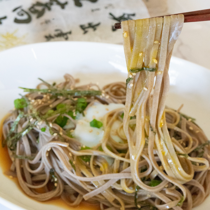 Man taking soba noodles with chopsticks