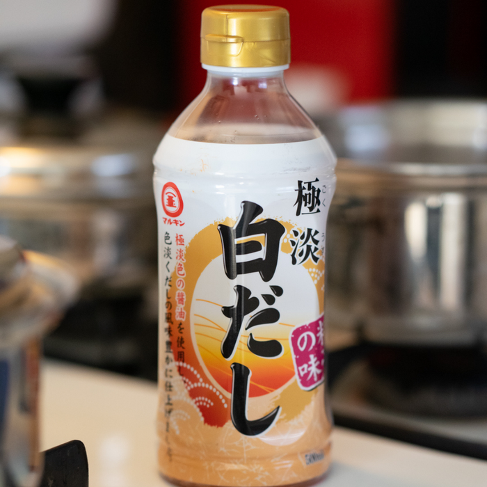 A bottle of shiro dashi surrounded by pots
