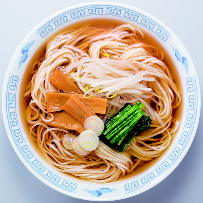 A bowl of gluten free ramen noodles with soy sauce based soup