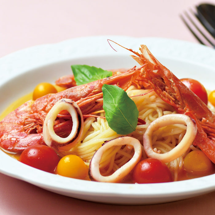 A plate of gluten free ramen noodles with shrimps, squid, and tomatoes