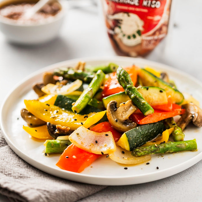 A plate of grilled vegetables in front of package of the product