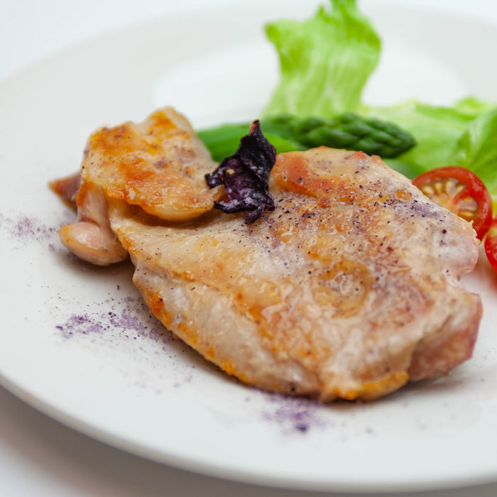 A plate of grilled chicken with rose salt