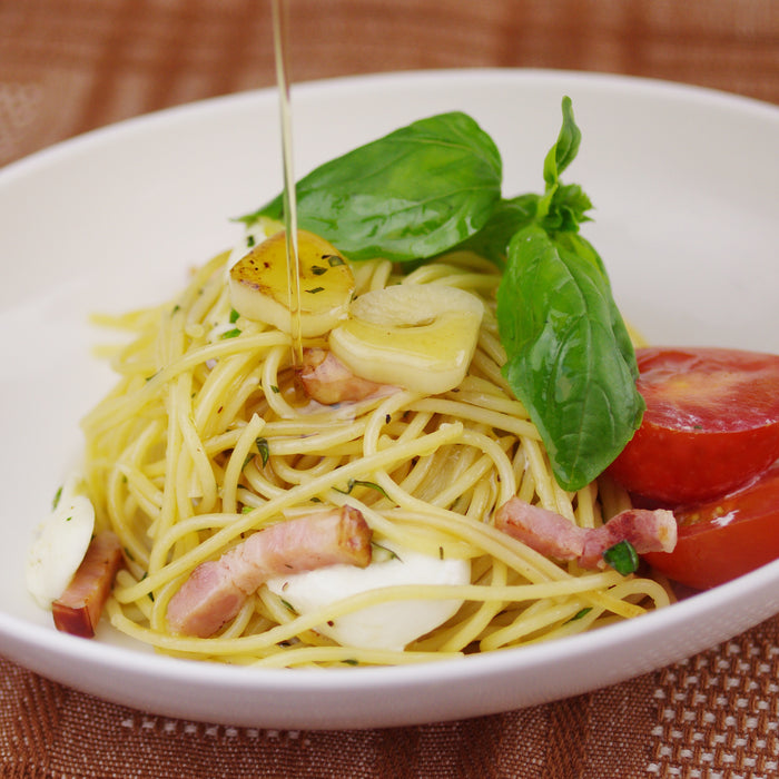 A plate of peperoncino being drizzled with sesame oil