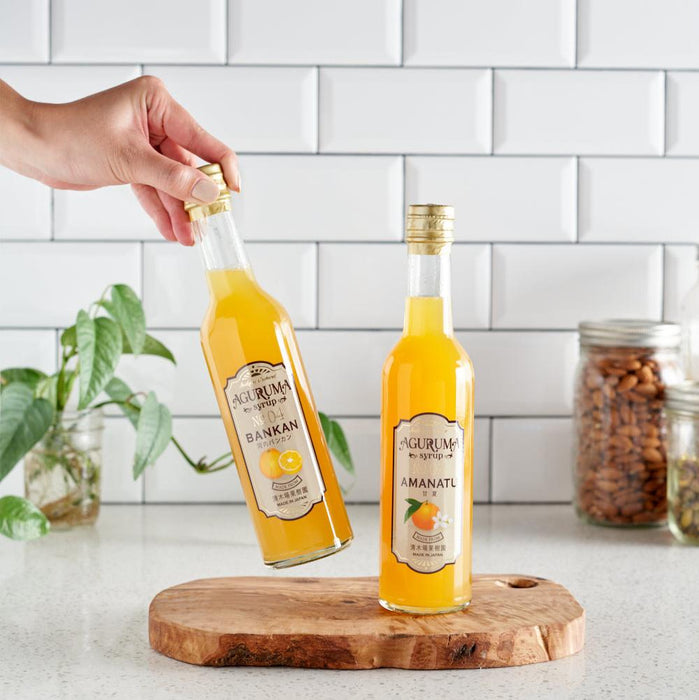 Two bottles of citrus syrup placed on cutting board