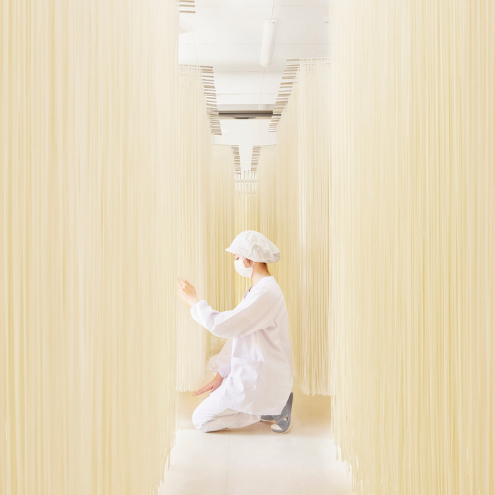 Woman stretching udon noodles