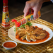 Drizzling motoi sauce on gyoza dumplings