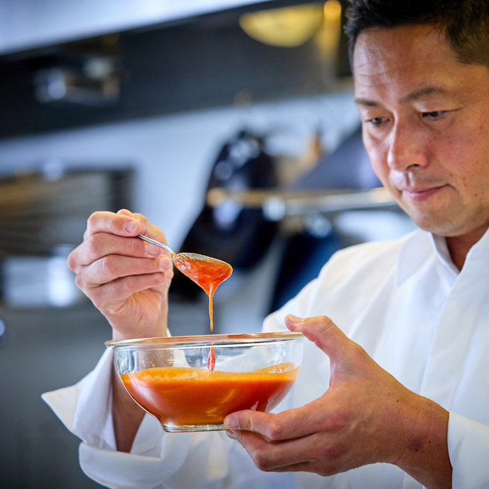 Man stirring motoi sauce using a spoon
