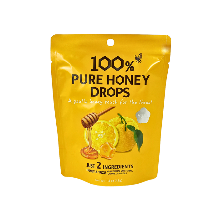 A yellow stand-up pouch of Yuji 100% Pure Honey Drops, featuring illustrations of lemons, honey, and a honey dipper on a white background.