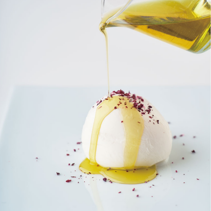 cheese topped with shiso furikake being drizzled with olive oil