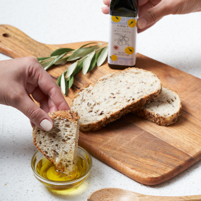 Man dipping bread into yuzu extra olive oil