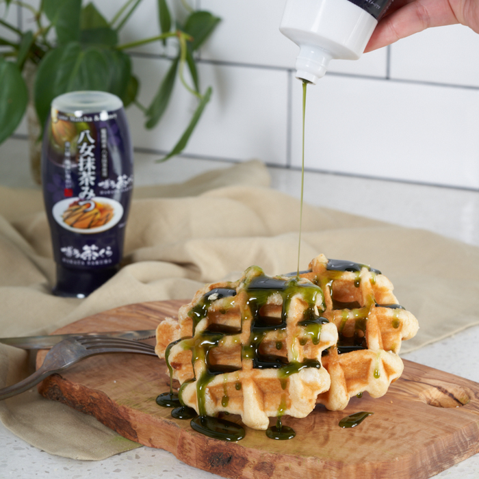 Man pouring matcha honey onto waffles