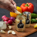 Man dipping radish into a jar of garlic shio koji paste