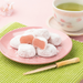 A plate of mochi being cut next to matcha bowl