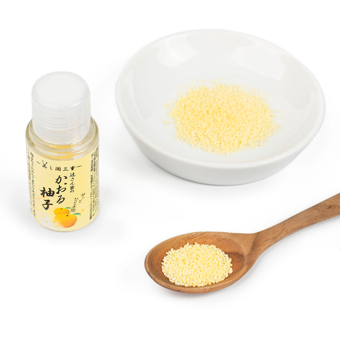 A spoon of powdered yuzu seasoning and a bowl of powdered yuzu seasoning next to a package bottle of the product