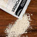 Okara powder popping out of a package bag of the product
