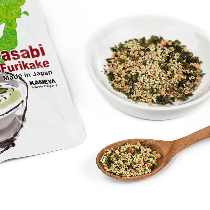 A spoon of wasabi furikake flakes next to the package and a bowl of wasabi furikake flakes