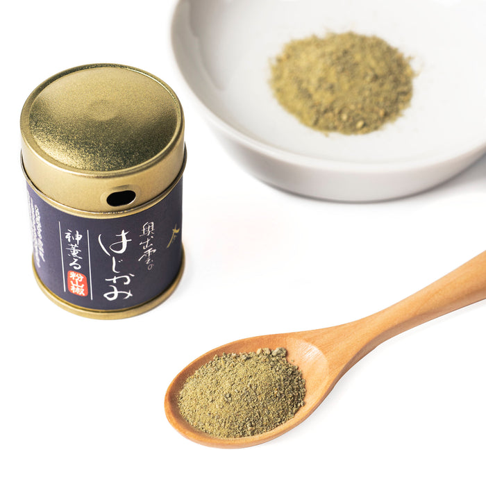 A spoon of sansho pepper powder and a bowl of sansho pepper powder next to bottle package of the product