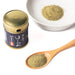 A spoon of sansho pepper powder and a bowl of sansho pepper powder next to bottle package of the product