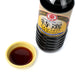 A small bowl of usukuchi light soy sauce next to bottle of the product