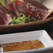 A bowl of shio ponzu and a plate of sashimi