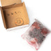 An internal package of organic umeboshi next to the package box with a hand-written thank you message 