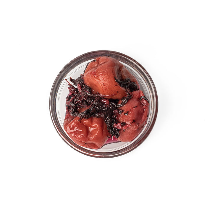 Overhead angle of three pieces of organic umeboshi on a small bowl